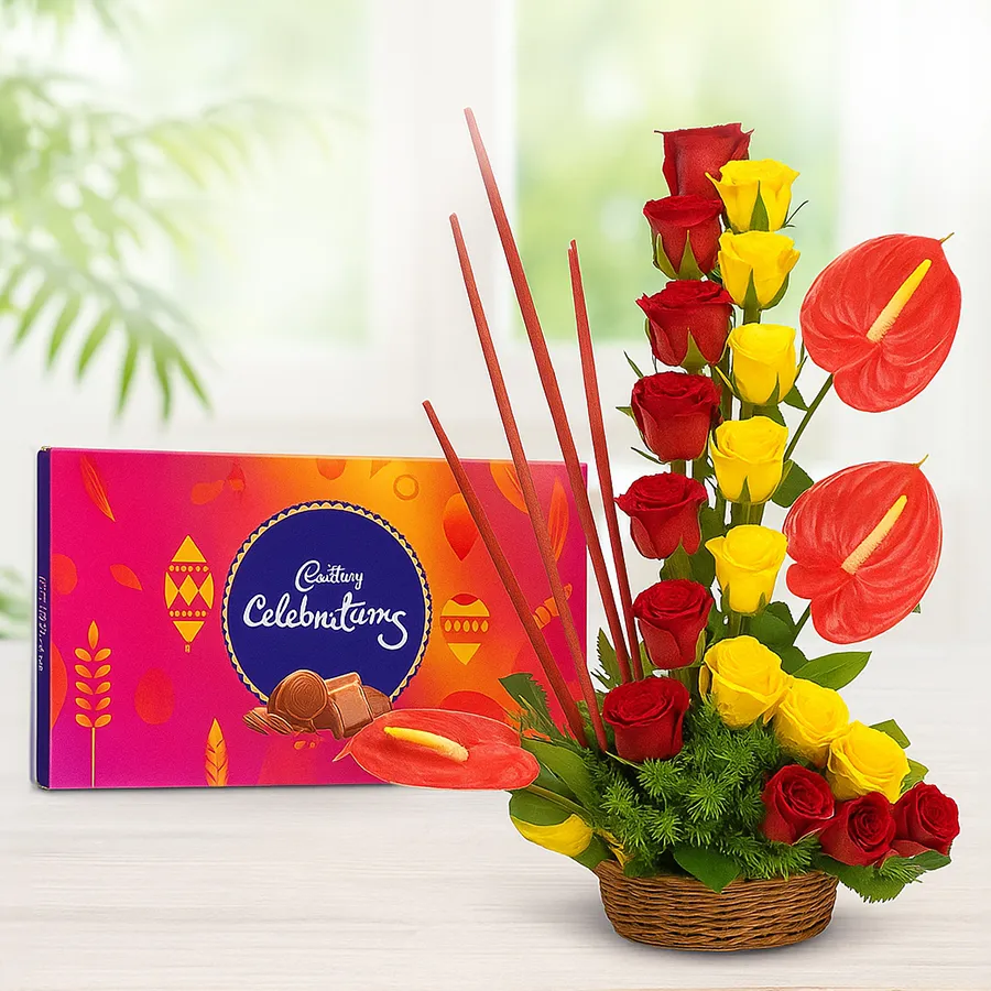 Beautiful floral arrangement featuring red and yellow roses, red anthuriums, and a Cadbury Celebrations gift pack.