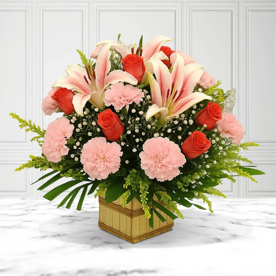 A vibrant basket arrangement featuring pink carnations, pink lilies, and orange roses, ideal for expressing love on special occasions.