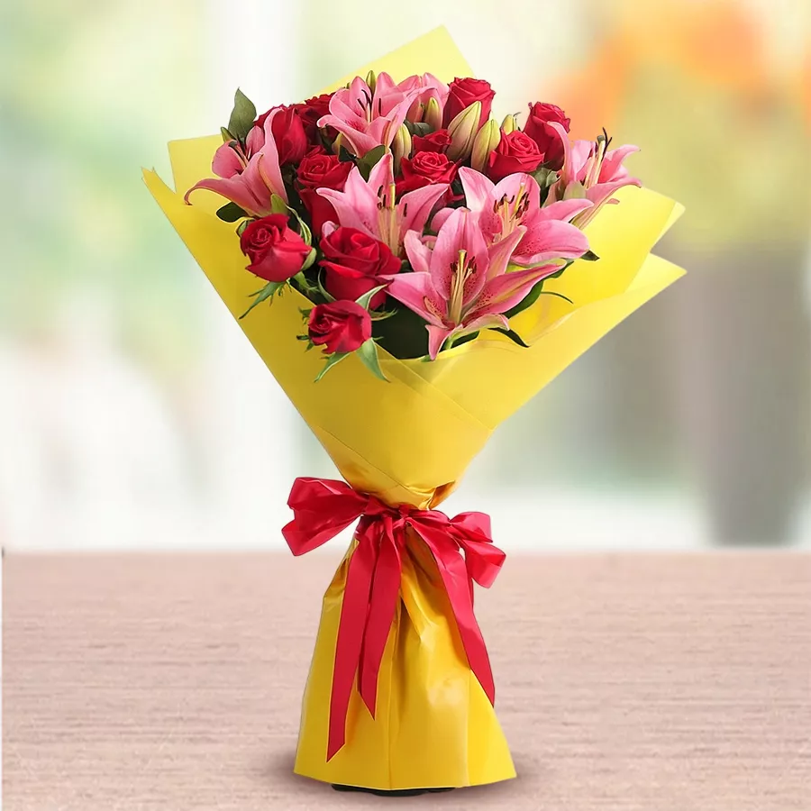 Romantic Blooms Ensemble featuring 15 red roses and 10 pink lilies in a beautiful arrangement.