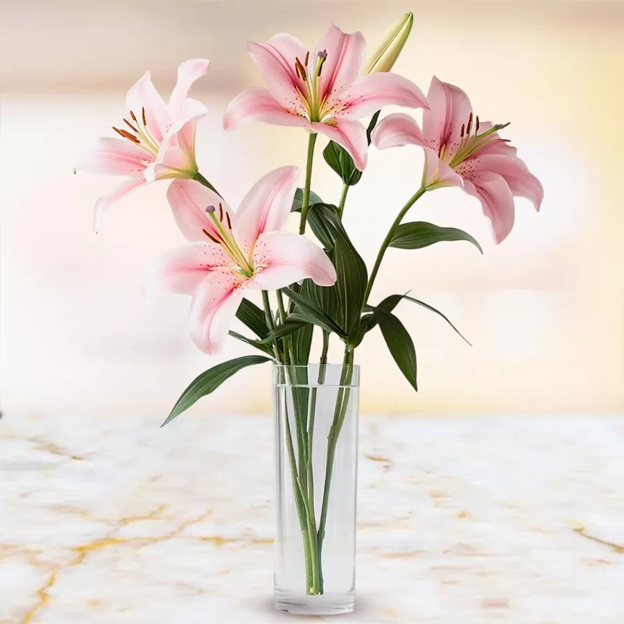 Gorgeous display of four pink lilies in a chic glass vase.
