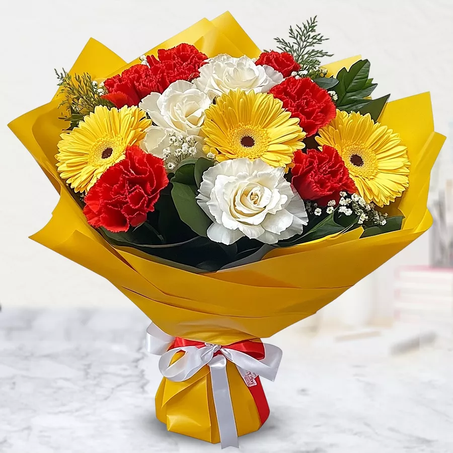 Exquisite arrangement of 7 roses, 5 carnations, and 3 gerberas wrapped in tissue, showcasing vibrant floral beauty.