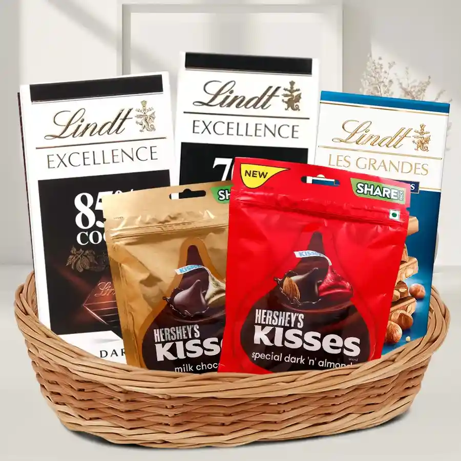 A beautifully arranged gift basket filled with Lindt Bar Chocolates and Hershey's Kisses, presented as a thoughtful gift for any occasion.