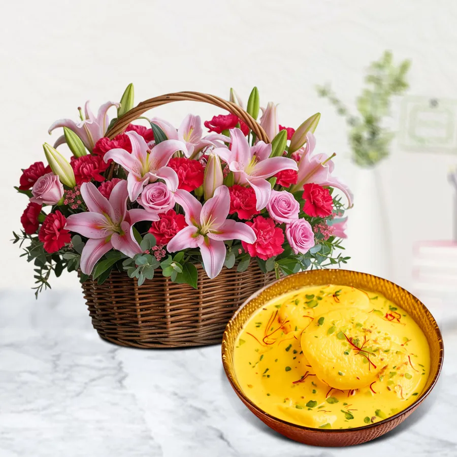 Arrangement of Pink Asiatic Lilies, Red Carnations, and Pink Roses with Kesar Rasmalai treats.