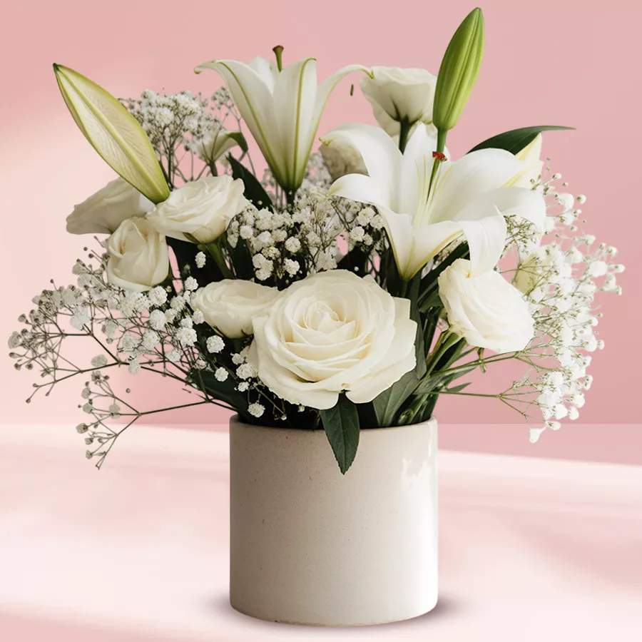 Elegant white floral arrangement in a ceramic pot, showcasing a mix of stunning white flowers.