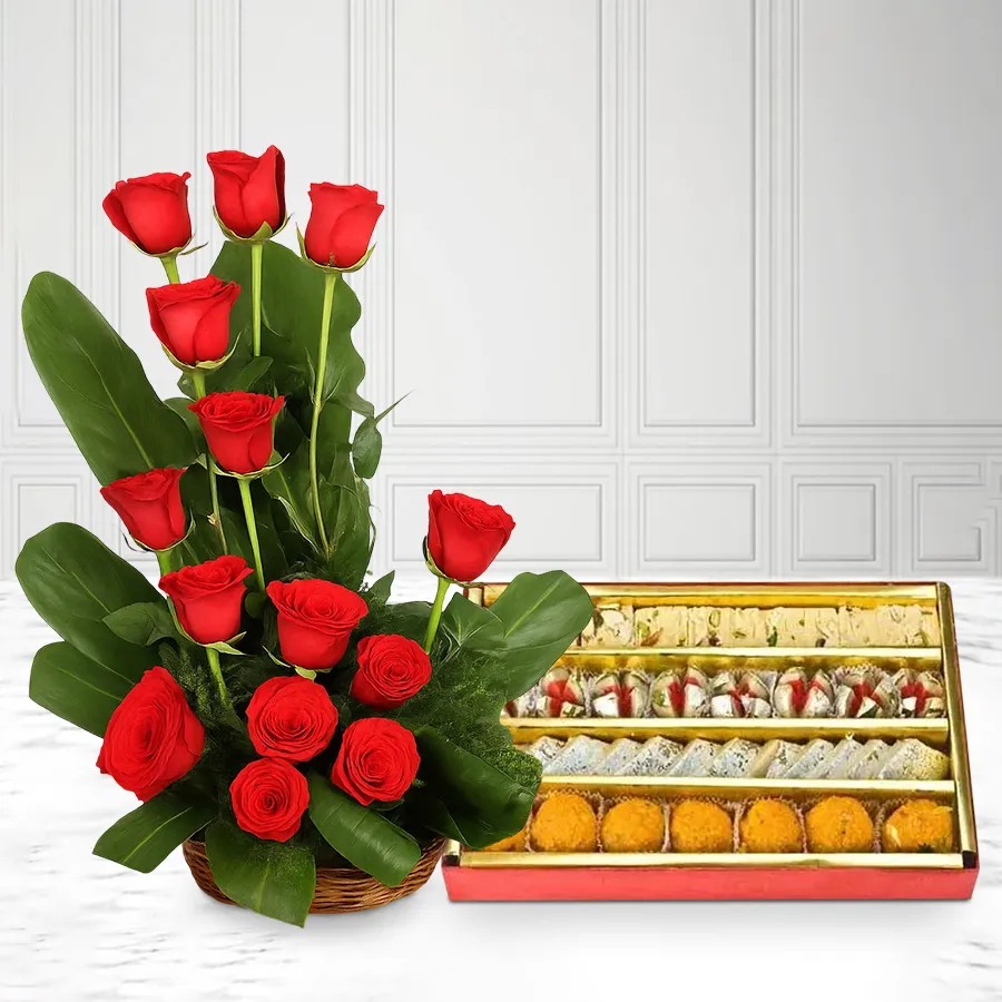 Arrangement of 18 red roses with a box of Haldirams mixed sweets.