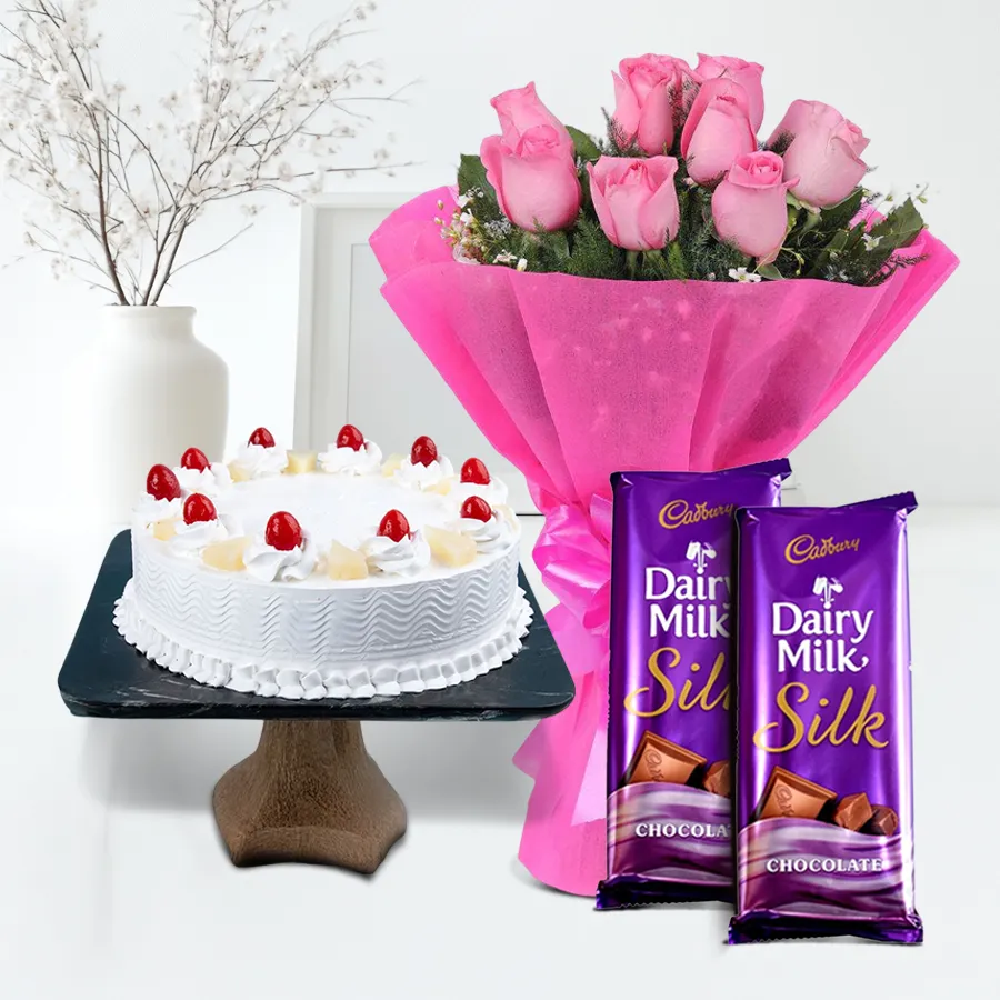 A delectable 1 kg Pineapple Cake with a bouquet of 10 pink roses and Cadbury Silk chocolate bars, perfect for special occasions.