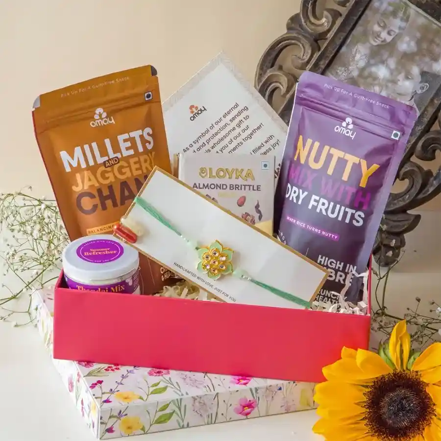Rakhi Joyful Essentials Gift Set featuring snacks, a handmade Rakhi, and a greeting card in premium packaging.