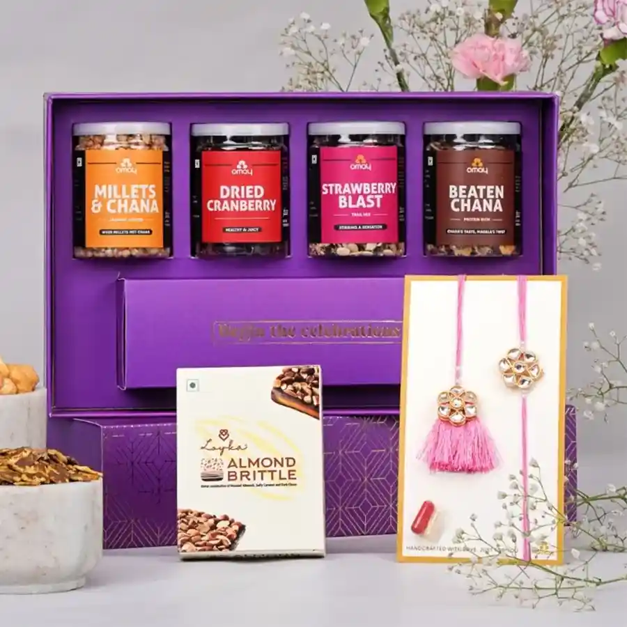 Premium Couple Rakhi Treat Box filled with snacks and a handmade rakhi, elegantly packaged in gold-foiled gift box.