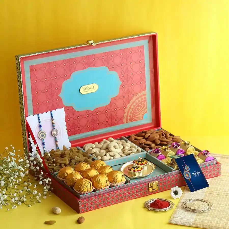 Special Rakhi Celebration Gift Set featuring Blue Evil Eye Rakhis, nuts, laddoos, handmade chocolates, and a greetings card for Rakhi celebrations.