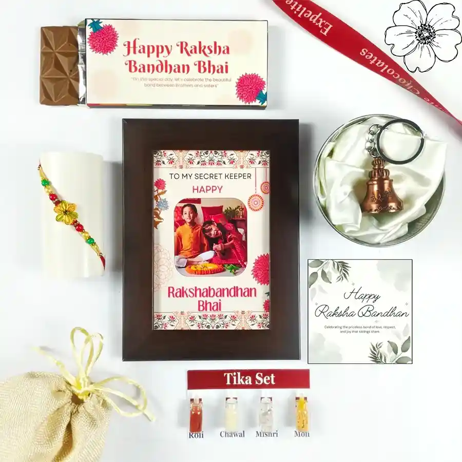 Eternal Bond Rakhi Ensemble featuring a chocolate bar, Rakhi, personalized photo frame, Tika set, greeting card, and guardian bell.