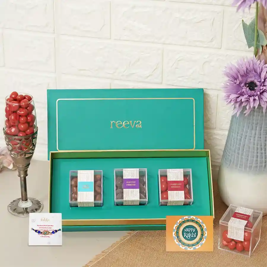 A gift set featuring dragees of raisins, almonds, cranberries, and an Evil Eye Rakhi, symbolizing love and protection for Raksha Bandhan.