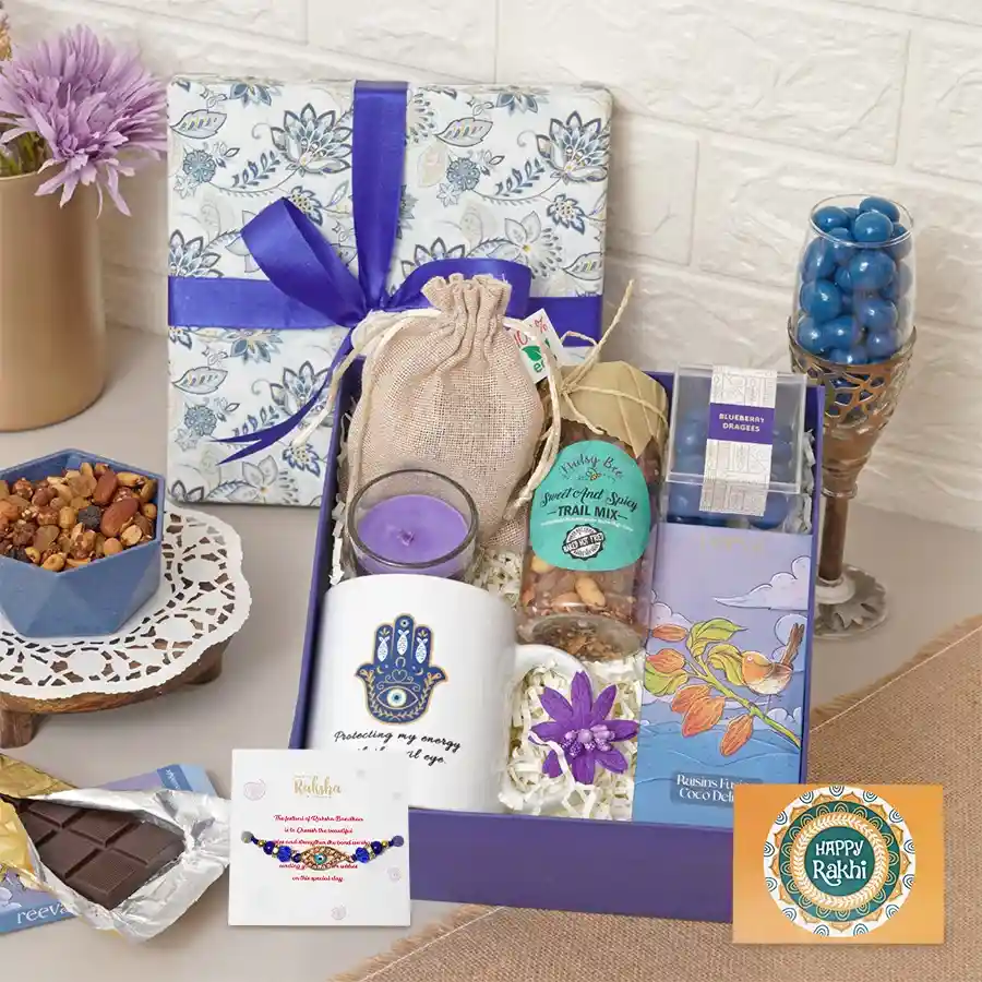 Rakhi Indulgence Delight Package with assorted treats, a mug, a candle, and a Rakhi with card.