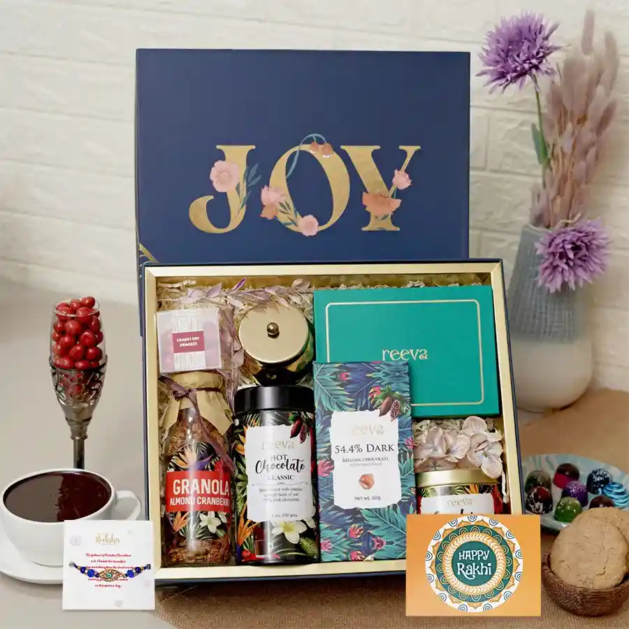 Tasteful Rakhi Indulgence Set featuring bon bons, chocolate, and a scented candle, perfect for celebrating sibling love.