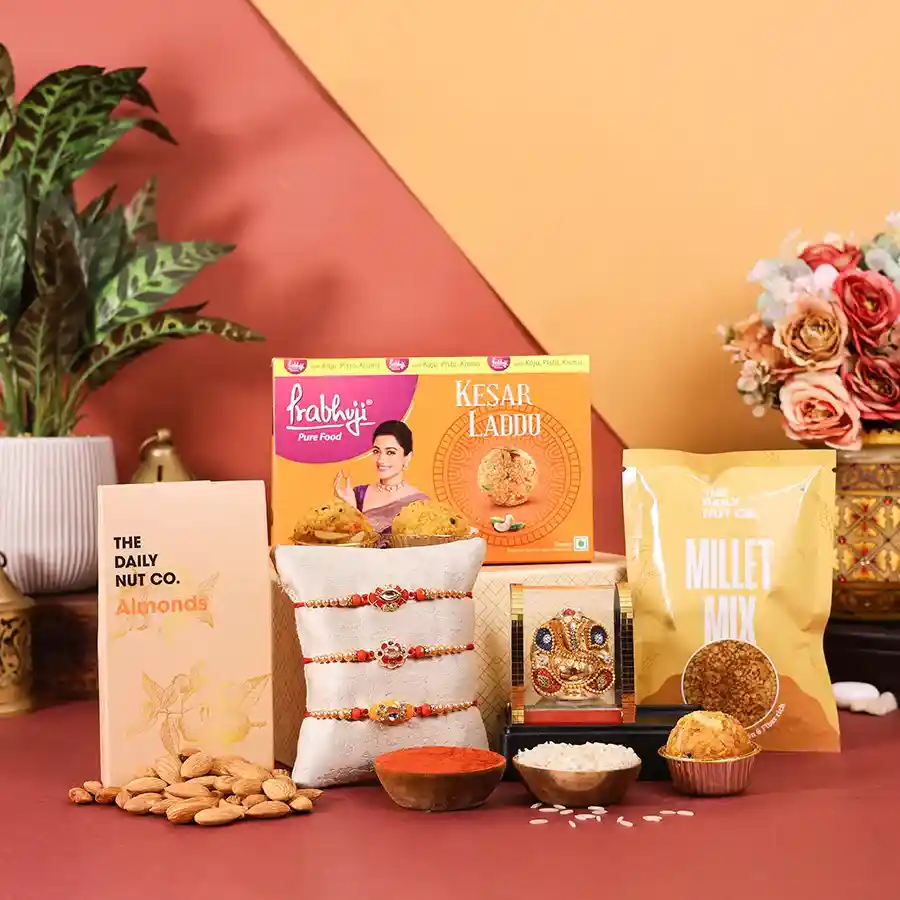 Traditional Rakhi Celebration Gift Box with designer Rakhi, sweets, nuts, and a Ganesh idol.