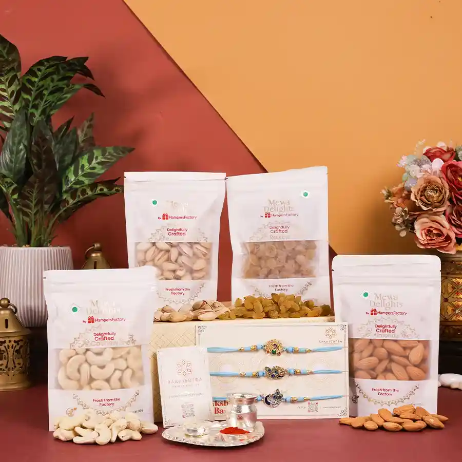 Raksha Bandhan Blessings and Treats Box featuring a designer Rakhi, silver-plated puja thali, assorted dry fruits, and traditional essentials.