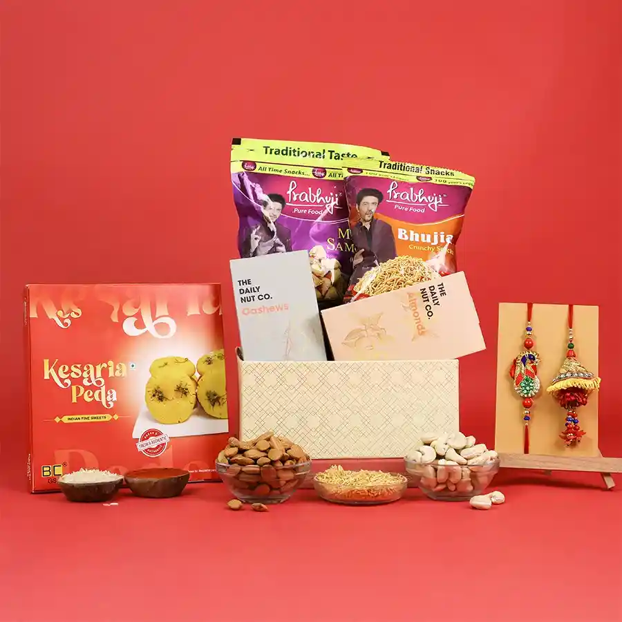 Beautifully arranged Rakhi gift hamper with sweets and snacks.