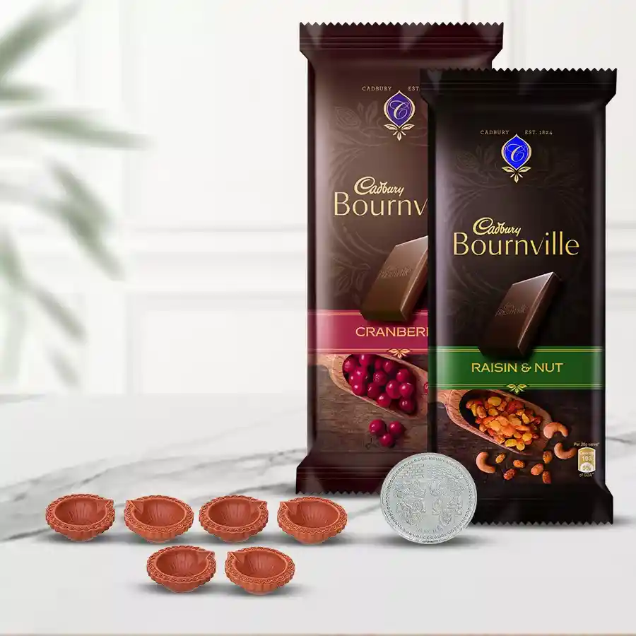 Diwali gift hamper featuring twin Cadbury Bournville chocolate bars, decorative mud diyas, and a silver-plated Ganesh Laxmi coin, all beautifully wrapped.