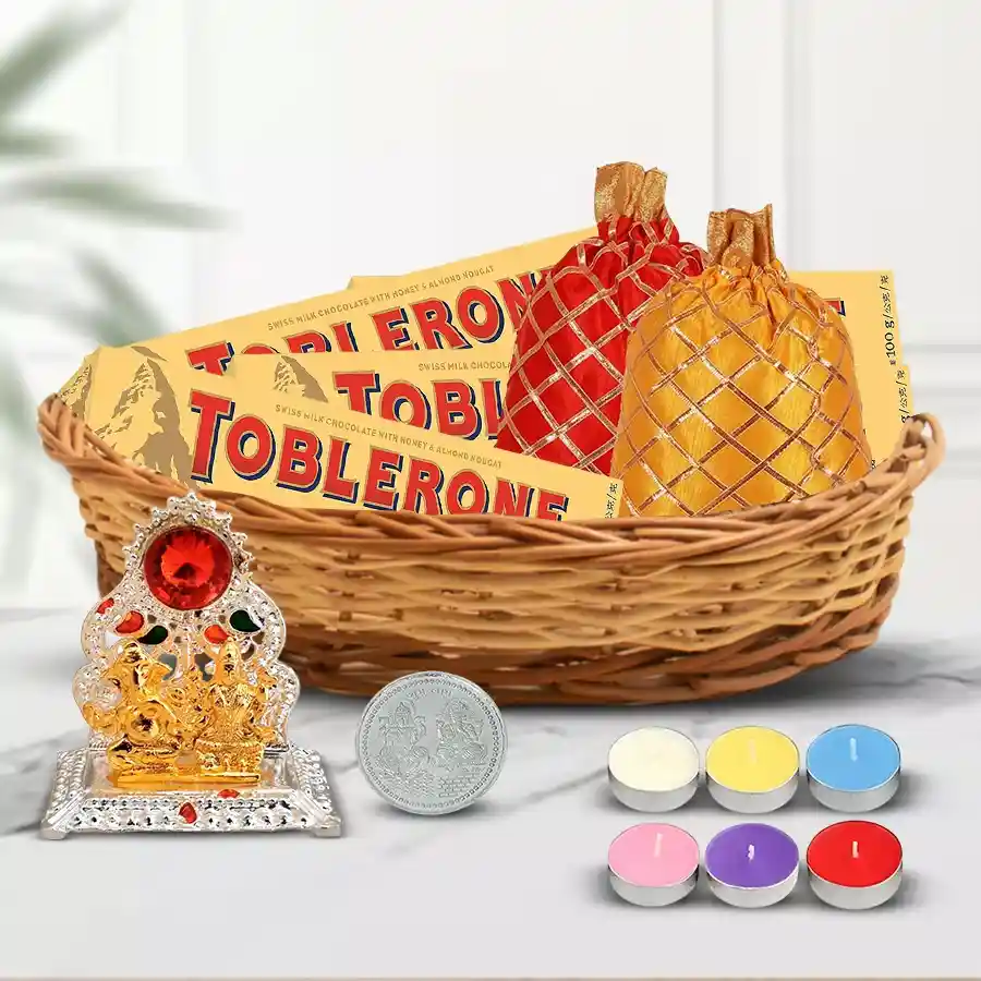 Marvelous Chocolates and Assortments Gift Hamper for Diwali including Toblerone chocolates, dry fruits, Laxmi Ganesh Mandap, tea light candles, Ganesh Laxmi coin, and a cane basket.