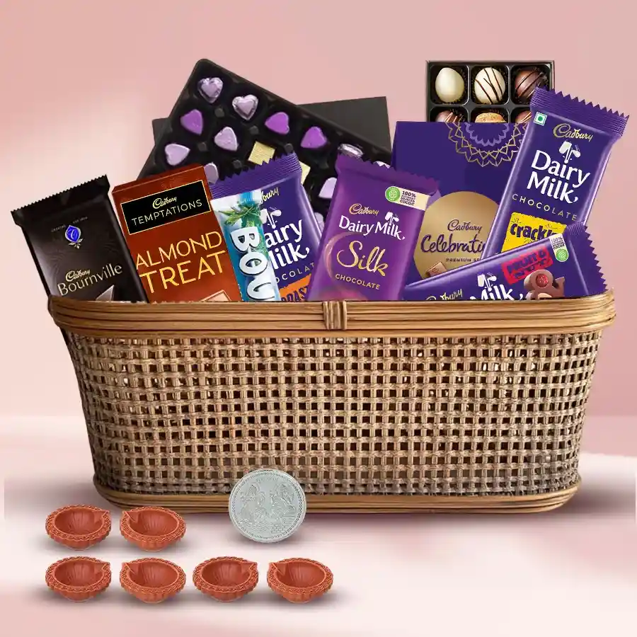 Remarkable Chocolates Gift Hamper for Diwali featuring assorted chocolates, Cadbury treats, mud diyas, silver-plated Ganesh-Laxmi coin, and a cane basket