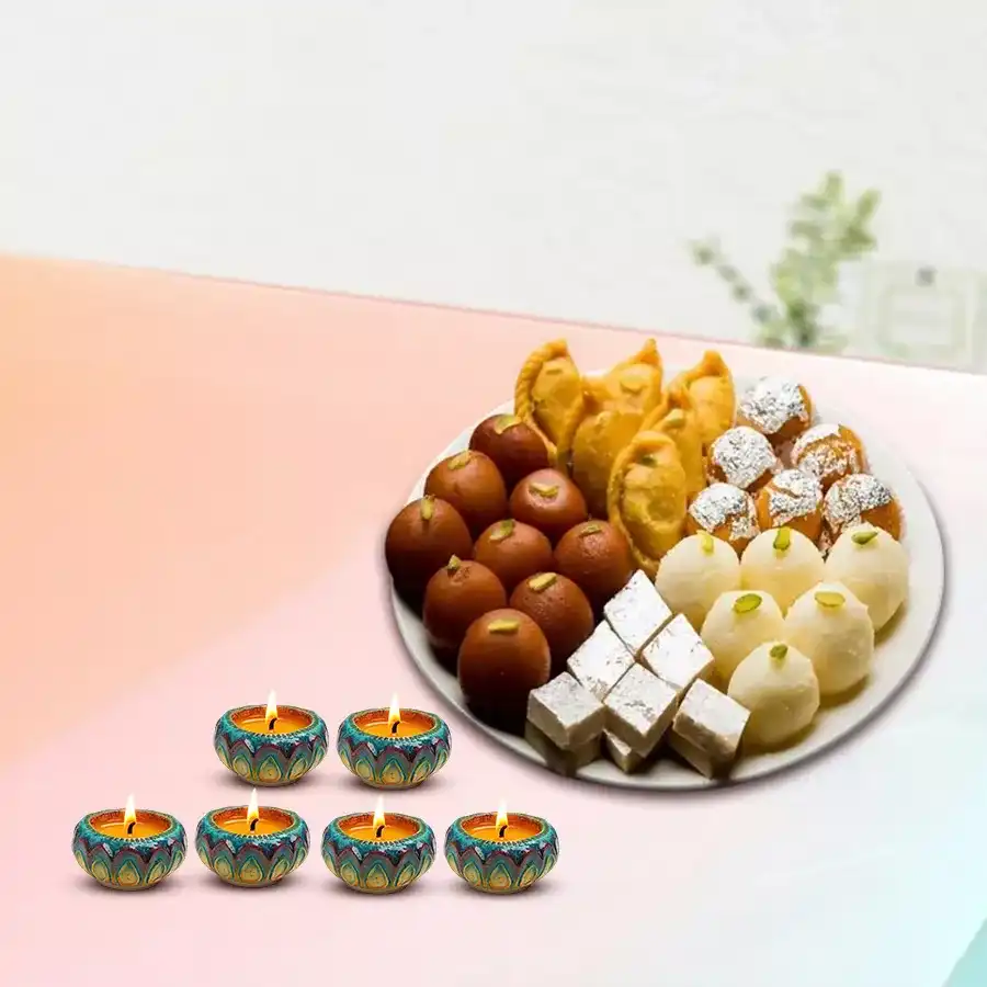 Delicious assorted Diwali sweets including Balusahi, Nariyal Laddus, Boondi Laddus, Kaju Katlis, Gulab Jamuns, and decorative Diyas arranged on a festive platter.