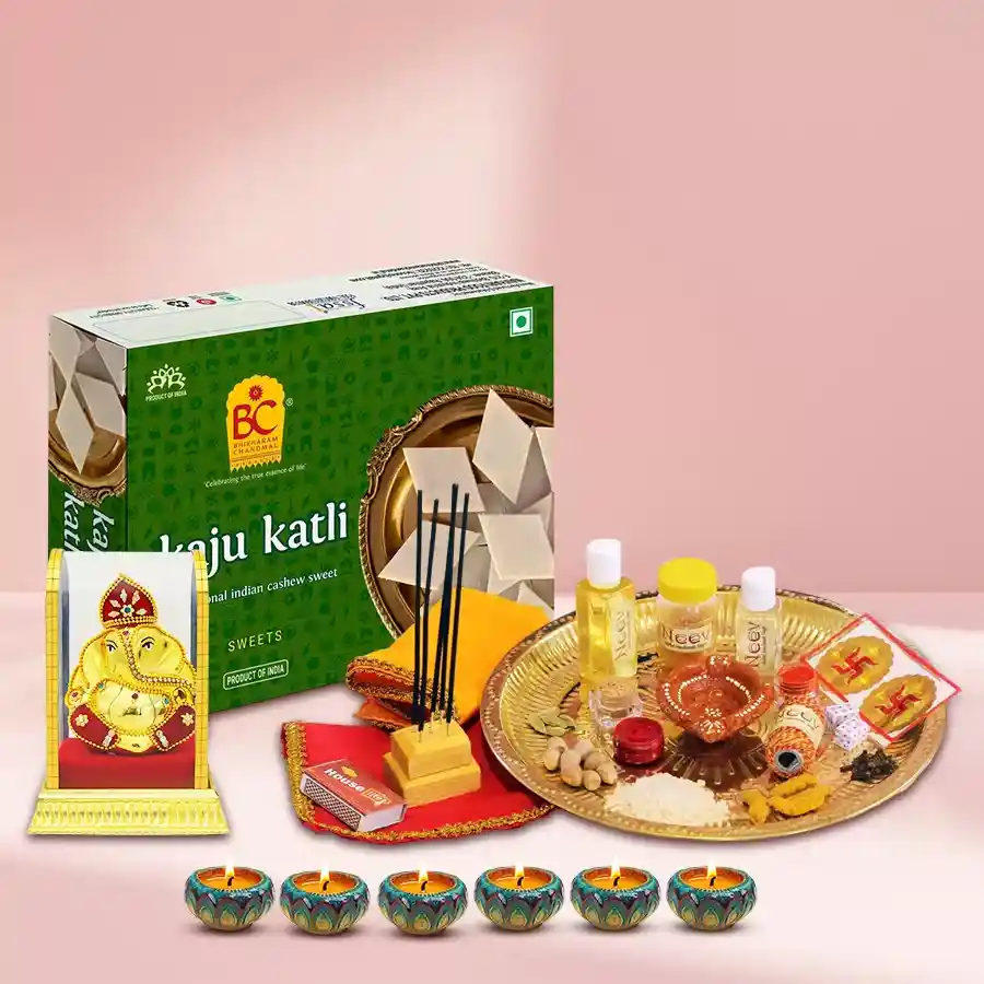 Tasty Kaju Katli gift pack with Ganesh idol, Diwali Pooja samagri, and decorated diyas
