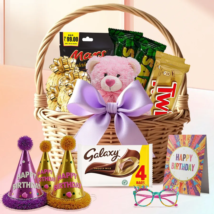 A beautifully arranged chocolate gift basket featuring Ferrero Rocher, Twix, Mars Miniatures, a Galaxy milk bar, a cute teddy bear, and colorful birthday accessories, all wrapped with a charming bow.