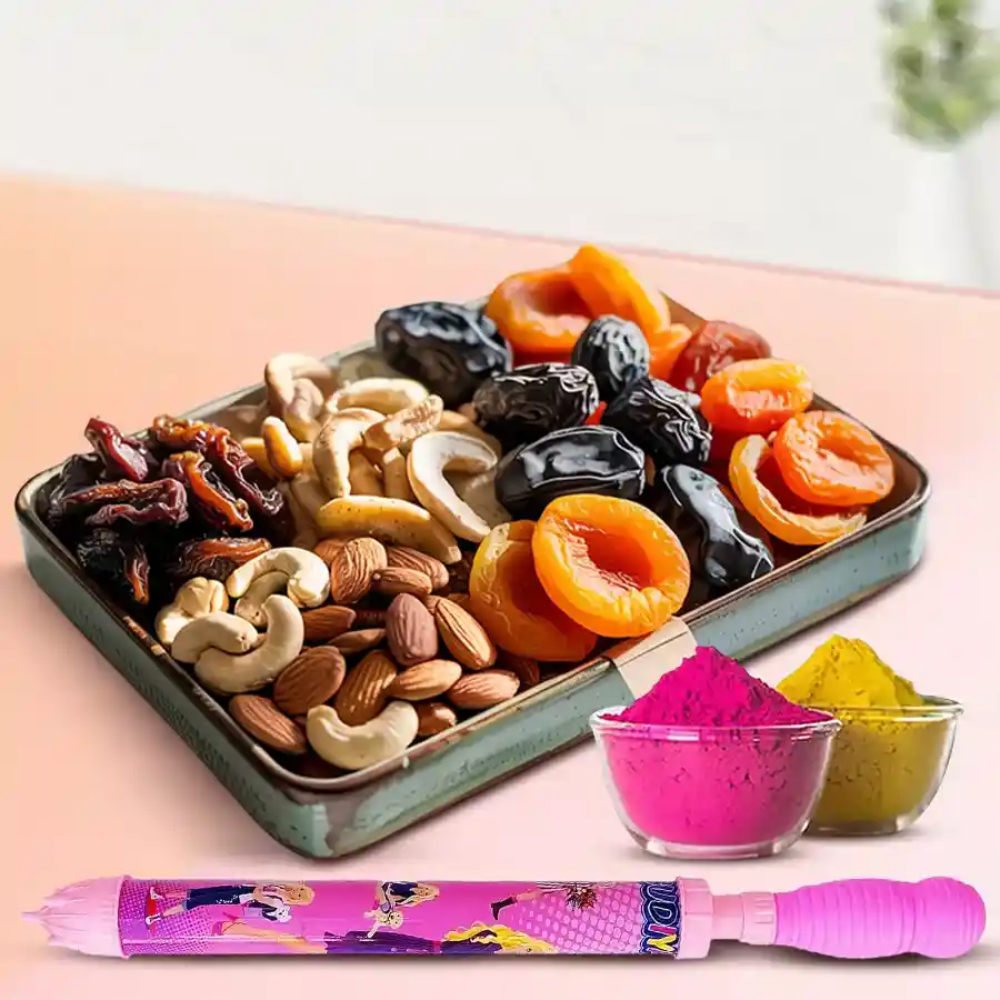 Assorted dry fruits gift tray for Holi including dried apricots, prunes, dates, roasted almonds, cashews, a colorful pichkari, and multicolor herbal gulal.