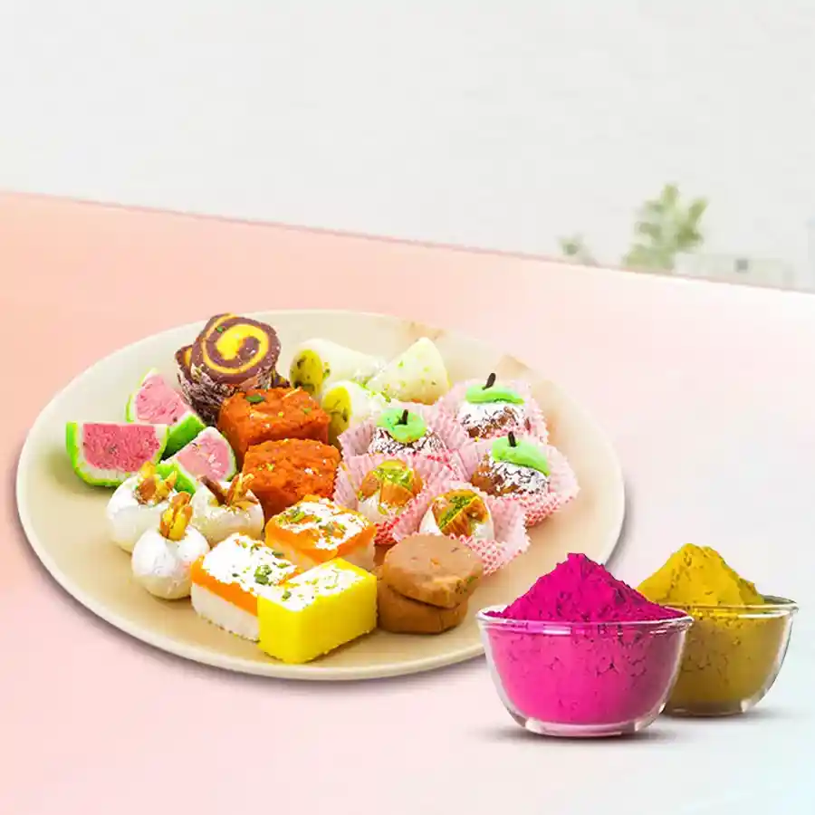 Exclusive mixed sweets from Bhikaram for Holi, featuring Kaju Paan, Kesar Peda, Mawa Apple, and Dilkhushal, with a pack of herbal Gulal.