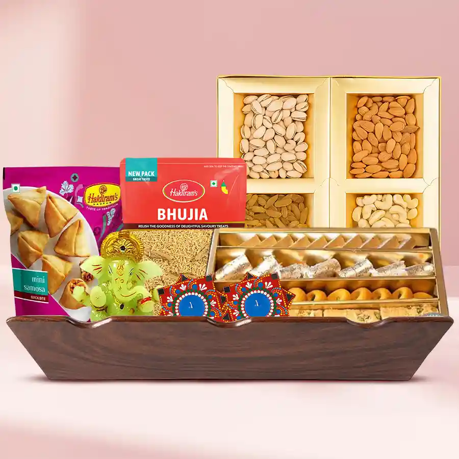 Awesome Diwali Sweet and Snacks Gift Basket featuring assorted dry fruits, Haldiram’s sweets, crispy Bhujia, mini samosas, a glowing Ganesh idol, and two handmade Dot Mandala Art Diyas on a wooden tray.