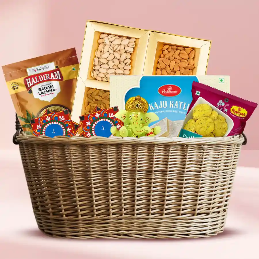Diwali gift hamper featuring dry fruits, Haldiram sweets, Ganesh idol, and Dot Mandala Art diya in a stylish basket