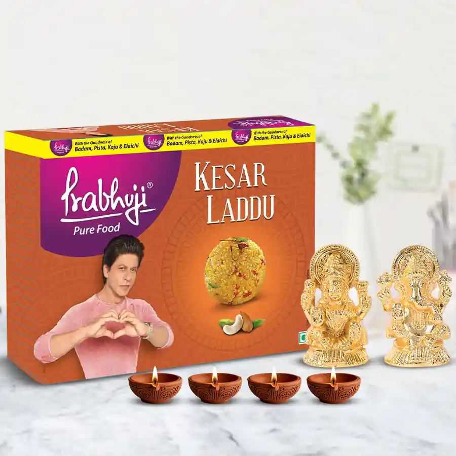 Home decor set featuring a gold-plated Lakshmi Ganesh idol, Haldiram Kesar Ladoo sweets, and terracotta diyas arranged for Diwali celebration.