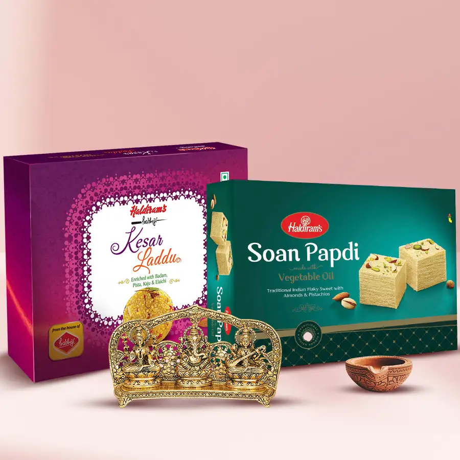 Beautiful Brass Metallic Lord Murti set with handcrafted statues of Lord Ganesh, Lakshmi Ji, and Saraswati Ji, Haldiram Kesar Laddu and Soan Papdi, and a terracotta mud diya.