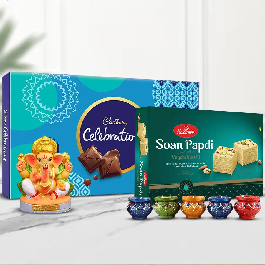 A festive gift hamper containing Cadbury chocolates, Haldiram Soan Papdi, a Ganesh idol, and vibrant Matka Diyas, perfect for Diwali celebrations.