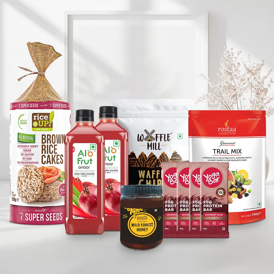 Terrific Winter Grace Xmas Hamper filled with Waffle Chocolate Chips, Rostaa Trail Mix, Avasa Wild Organic Honey, Alo Pomegranate Juice, Yoga Protein Bars, and Rice Up Brown Cakes with 7 seeds.