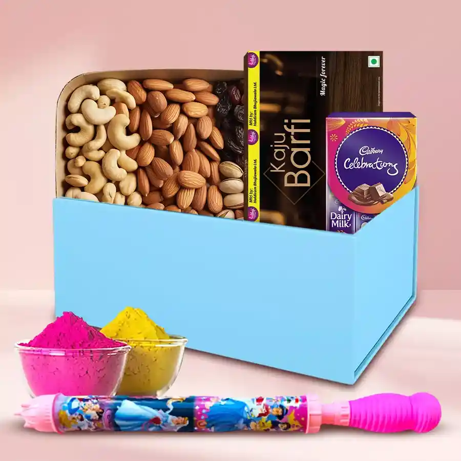 Colorful gourmet treat box for Holi featuring cashews, almonds, raisins, pistachios, Haldiram Kaju Barfi, Cadbury Celebrations chocolates, a long pitchkari, and herbal gulal packets.