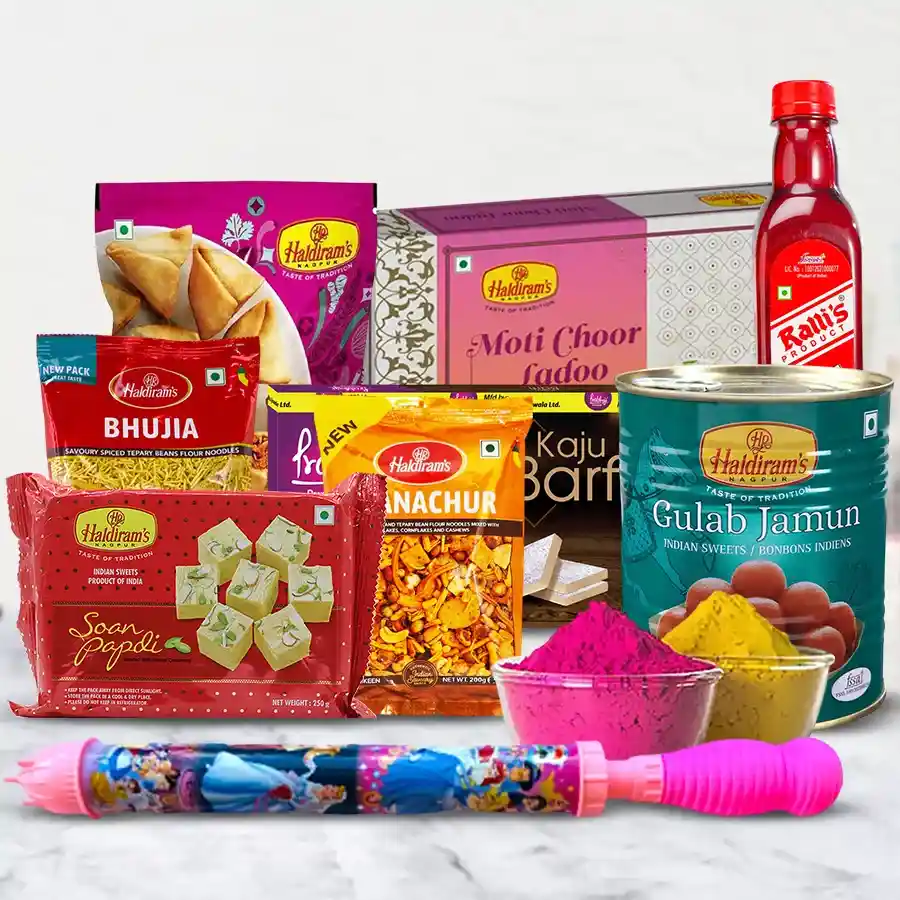 Holi special gift box containing Haldiram treats like Mini Samosa, Chanachur, Soan Papdi, Kaju Barfi, Bhujia, Laddu, and Gulab Jamun, with Ralli Singh Sharbat Rose, a Pitchkari, and herbal Gulal packets