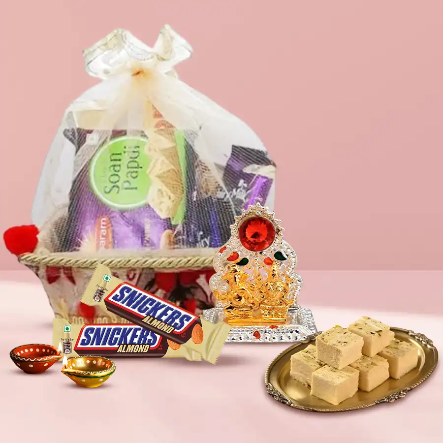 Diwali Treat Hamper featuring Haldiram’s Soan Papdi, Snickers Almond bars, decorative wax diyas, and Ganesh Laxmi Mandap in an elegant gift basket
