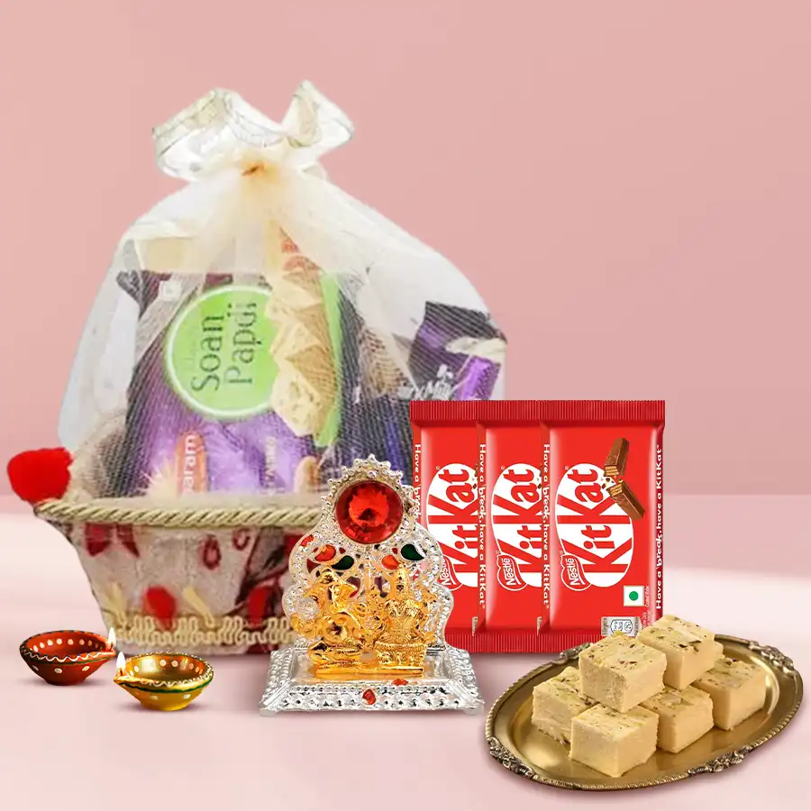 Diwali sweets hamper featuring Soan Papdi, Nestle KitKat chocolates, wax diyas, and a Ganesh-Lakshmi mandap, presented in a decorative gift basket