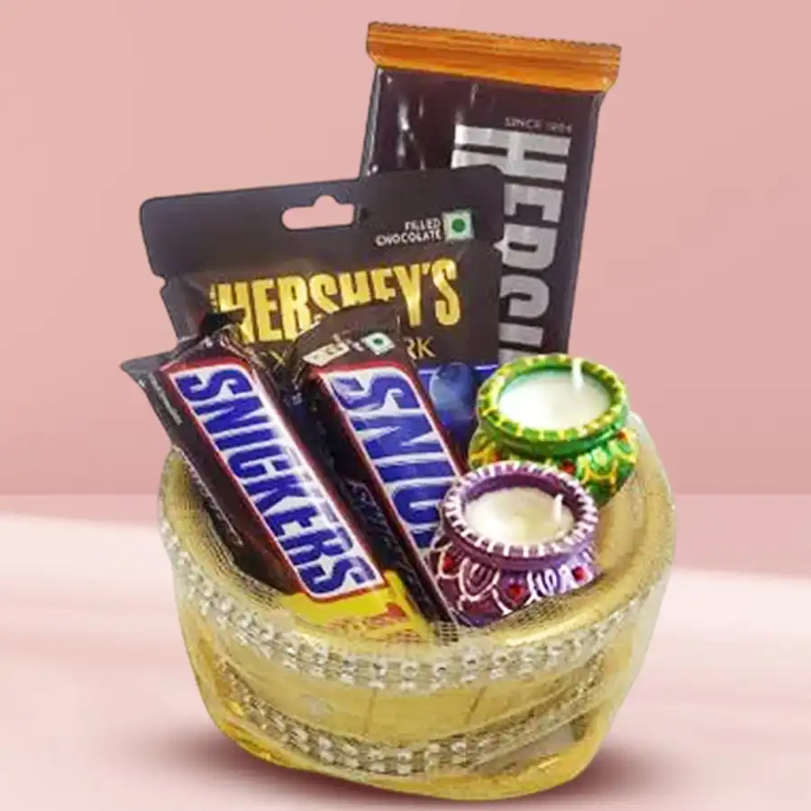 Happy Diwali Chocolates Unbound Hamper featuring decorated wax diyas, Hershey’s Almond bars, Snickers Almond bars, and chocolate-coated raspberries in a decorative gift basket.