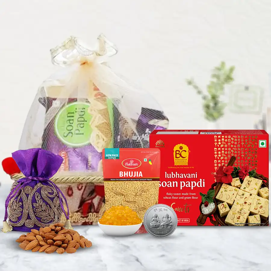 Sweets n Munchies Delight Hamper featuring Haldiram Soan Papdi, Bhujiya, Kesaria Mishri, Almonds Potli, and a silver-plated Ganesh Lakshmi coin in a decorative gift basket.