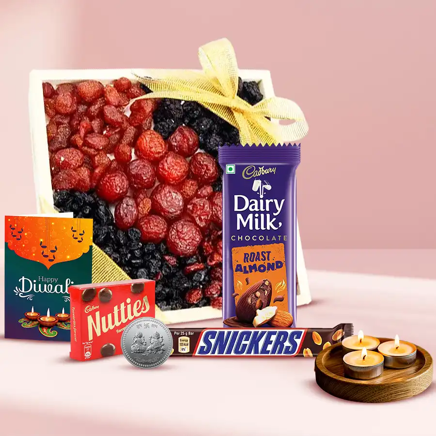 Toothsome Mixed Berries Diwali Treat displayed in a reusable wooden tray, featuring a blend of mixed berries, assorted chocolates, tea light candles, a silver-plated Ganesh Lakshmi coin, and a Diwali wishing card.