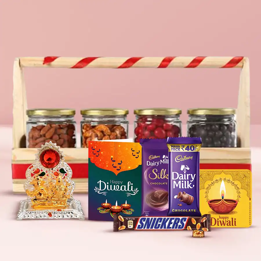 Healthy n Tasty Diwali Gift Combo featuring a wooden basket filled with dried kiwis, pineapples, orange slices, Cadbury Dairy Milk Silk, Dairy Milk, Snickers bar, Ganesh-Laxmi Mandap, handmade fridge magnet, and a Diwali wishing card.