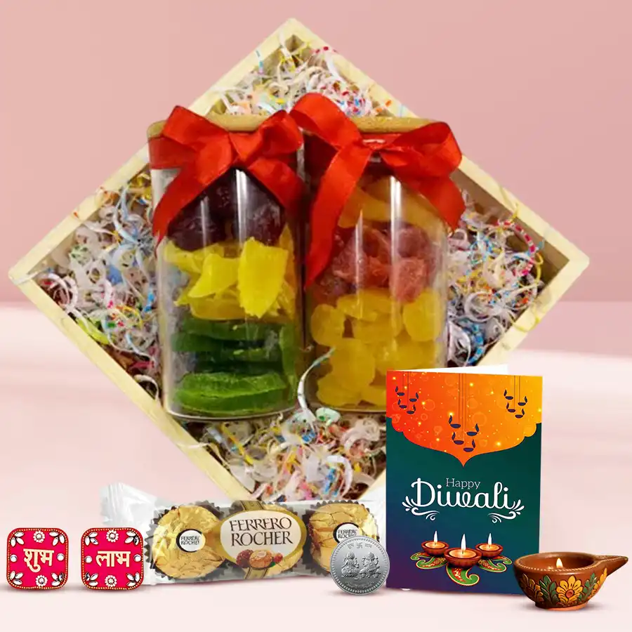 Diwali gift hamper featuring a wooden basket with glass jars of dried fruits, Ferrero Rocher chocolates, a designer diya, Shubh Labh wall stickers, a silver-plated coin, and a Diwali greetings card.