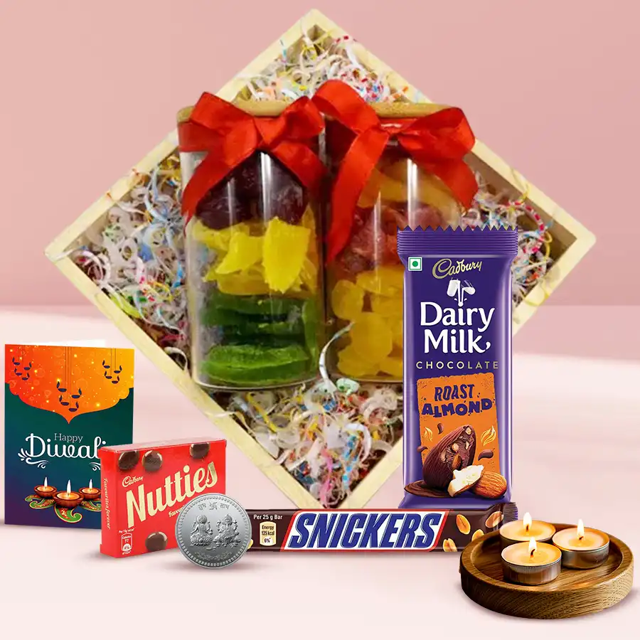 Festive Diwali combo including a wooden tray with glass jars of dried fruits, chocolates, tea light candles, a silver-plated Ganesh Laxmi coin, and a greeting card.