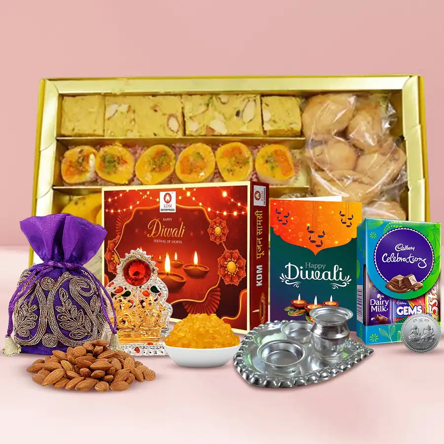 A beautifully arranged gift box filled with traditional Diwali sweets, savory snacks, chocolates, almonds, and festive essentials like a Ganesh Laxmi Mandap and a silver pooja thali, accompanied by a personalized Diwali card.