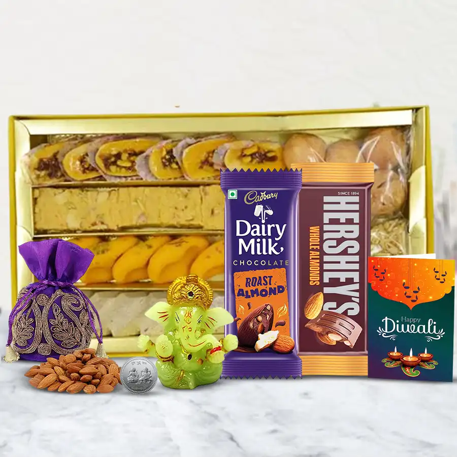 Festive hamper filled with Kaju Katli, Soan Papdi, Cadbury and Hershey's chocolates, a Silver Ganesh Laxmi Coin, a Ganesh idol, almond potli, and a Diwali card.