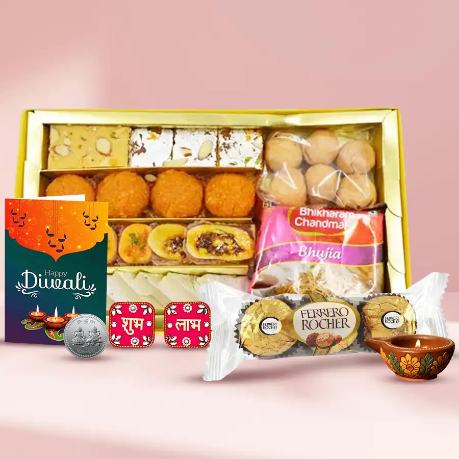 Diwali gift hamper featuring Soan Papdi, Kaju Katli, Ferrero Rocher, a fancy diya, colorful wall stickers, and a silver-plated Ganesh & Lakshmi coin, accompanied by a festive Diwali card.