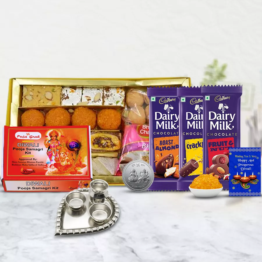 Festive Diwali gift hamper with sweets, snacks, chocolates, pooja thali, coins, and a greeting card