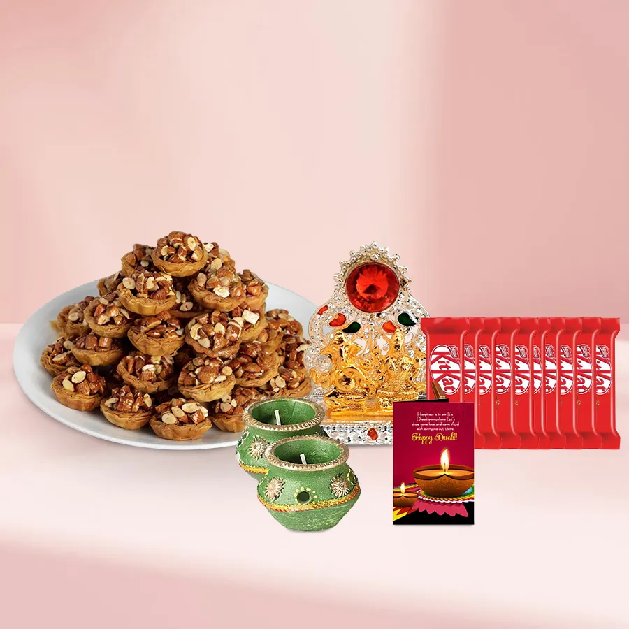Special Tart Baklava and KitKat Moments Basket with decorative wax diyas and Ganesh Lakshmi Mandap, arranged in an elegant basket
