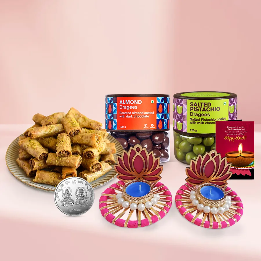 Assorted Diwali sweets including dragees, baklava, lotus diyas, and a Ganesh & Lakshmi coin with a Diwali card.